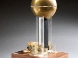 une image représentant un globe doré posé sur un socle en bois
