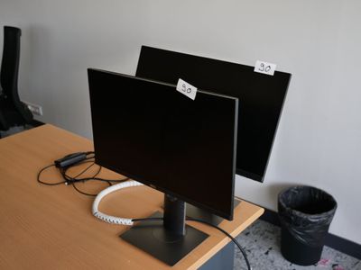 un bureau sur lequel se trouvent deux écrans et un téléphone