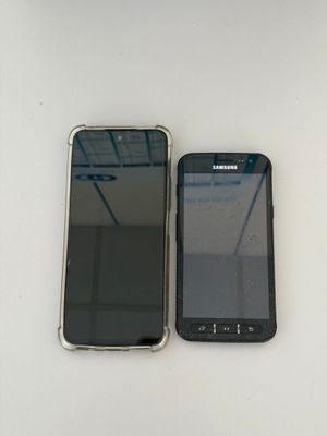 two cell phones sitting next to each other on a table