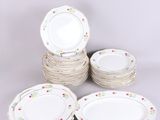 six assiettes blanches ornées de fleurs colorées, empilées les unes sur les autres