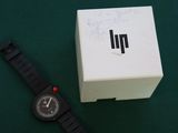 a watch sitting next to a box with writing on it