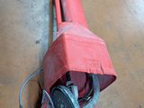 a red blow dryer sitting on the floor in a room