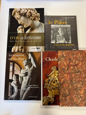 Plusieurs livres sont posés sur une table, avec une horloge devant eux.