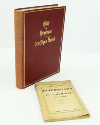 un vieux livre posé sur une table blanche à côté d'un livre