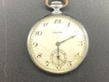 a silver pocket watch on a black surface