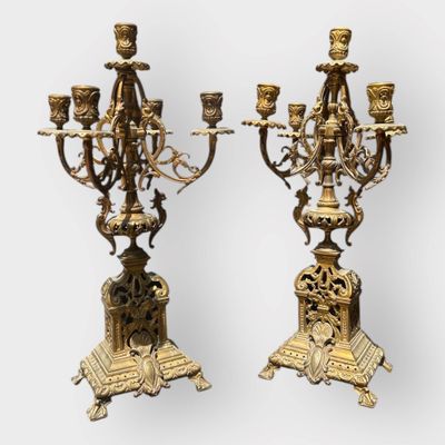 pair of antique brass candelabs with candles on stands