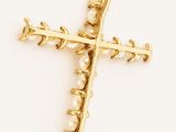 a close up of a gold cross with pearls on it