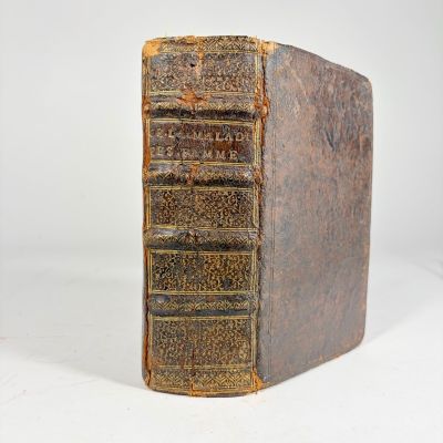 an old book sitting on top of a white table next to a white wall