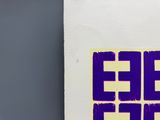 a purple and yellow sticker on a white piece of paper