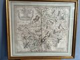une vieille carte de l'Angleterre dans un cadre doré accrochée à un mur bleu