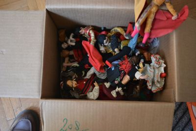 a cardboard box filled with toy figurines and a pair of shoes