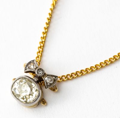 une photo d'un collier en diamants et en or monté sur une chaîne en or