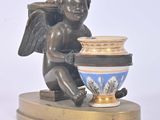 une statue représentant un ange tenant un vase posé sur un socle