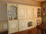 a dining room with a wooden table and a white china cabinet