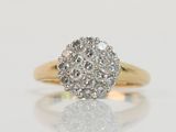 an image of a diamond cluster ring on a reflective surface