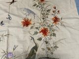 une image représentant une nappe ornée d'un paon et de fleurs