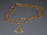 un gros plan d'une chaîne en or ornée d'un pendentif en forme de triangle