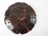 a rusted plate on a white surface with a white background