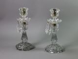 pair of clear glass candlesticks sitting on top of a table