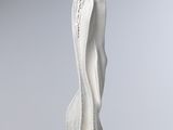 sculpture of a woman ' s torso on a base on a white surface