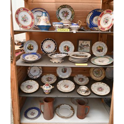 de nombreuses assiettes et tasses sur les étagères du placard