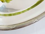 a silver plate with a bunch of green grapes on it