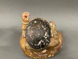 a figurine of a turtle with a ball on it ' s back
