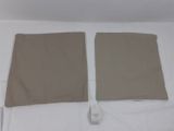 une paire de draps beiges sur un lit, avec une télécommande
