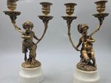 paire de bougeoirs anciens en laiton ornés de chérubins, sur des socles en marbre