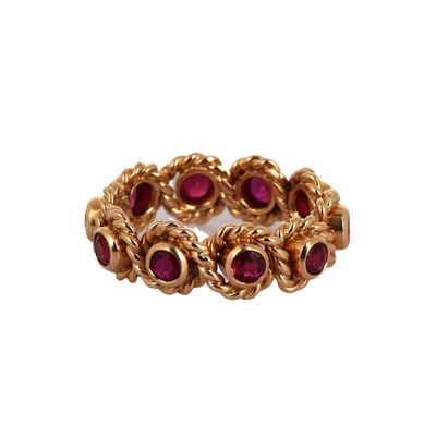 un gros plan d'une bague en or sertie de pierres rouges
