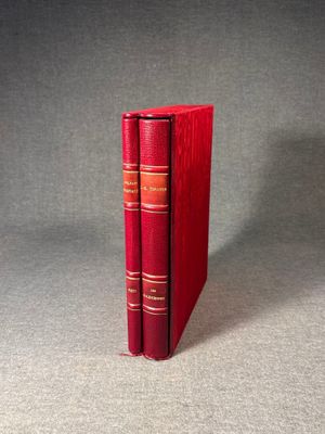 two red books sitting on top of each other on a table