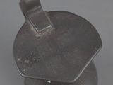 an old metal object with a metal handle on a gray surface