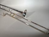 le trombone est posé sur une surface blanche, avec un fond blanc