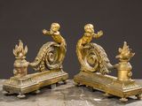 two gold statues on a marble table with a black background