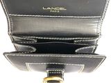 a close up of a black purse with a gold ring on it