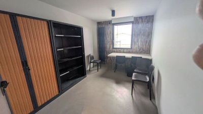 Quelqu'un prend une photo d'une pièce où se trouvent un bureau et des chaises