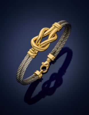 a gold and silver bracelet with a knot on it