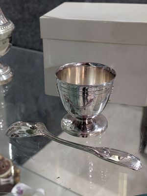 a glass table with a silver bowl and spoons on it