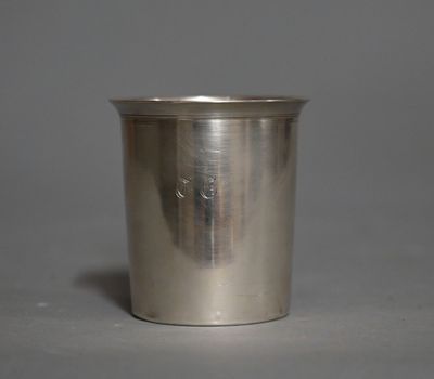 une coupe ancienne en argent avec une anse, sur fond gris