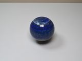 une bille bleue posée sur une surface blanche
