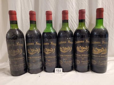six bottles of red wine are lined up on a table