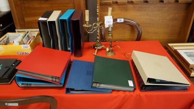 de nombreux livres posés sur une table sur laquelle se trouve une bougie