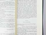 an open book on a table with a green ribbon around it