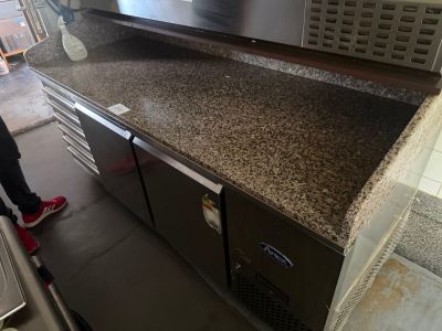 a person standing in front of a counter with a microwave on it
