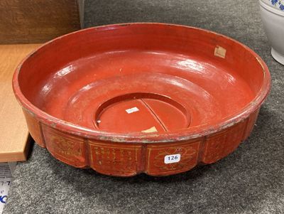 un bol rouge posé sur une table à côté d'une boîte