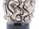 silver sculpture of a ball of metal on a black stand
