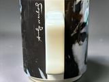 a cup with a picture of a cat and a glass of milk