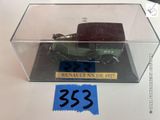 une petite voiture miniature dans une boîte transparente posée sur une table