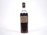 une bouteille d'alcool posée sur une surface blanche