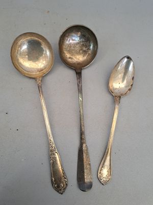 trois cuillères en argent et deux cuillères en argent posées sur une table